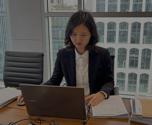 노트북을 보며 서류를 검토하는 정장 차림 사람